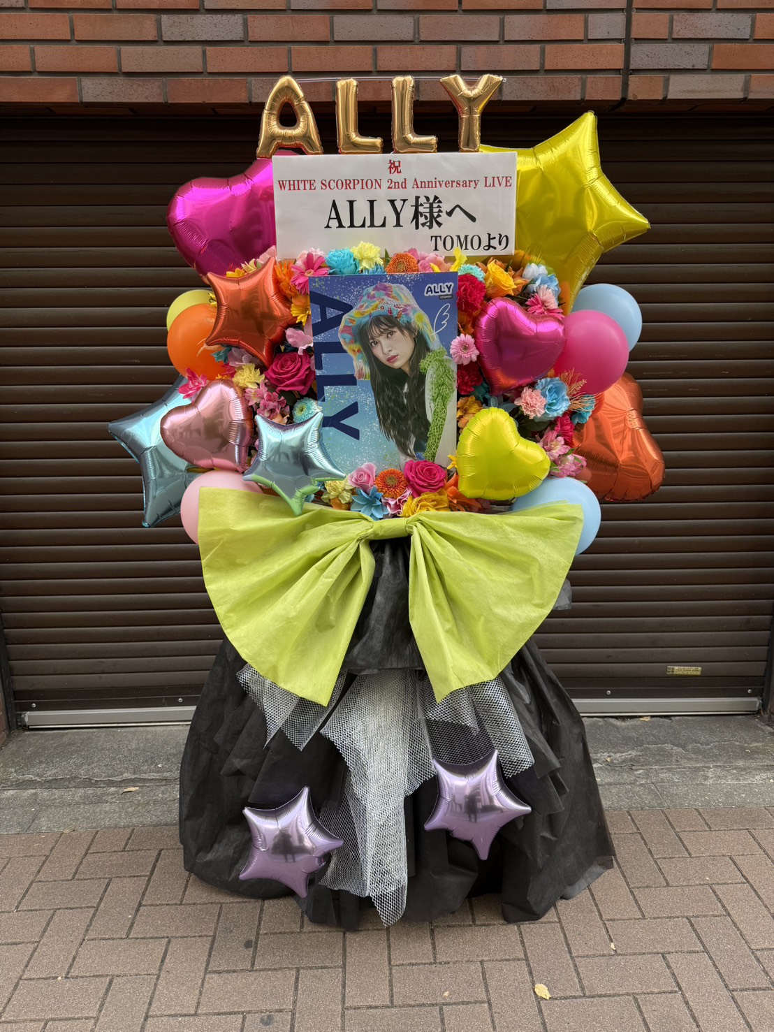 WHITE SCORPION 2nd Anniversary LIVE 様 フラスタ - ピンク、黄、緑を基調としたバルーン、生花スタイルのフラワースタンド。価格帯：5~10万円